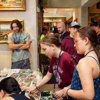 students examine poster of fish and macros at student project showcase
